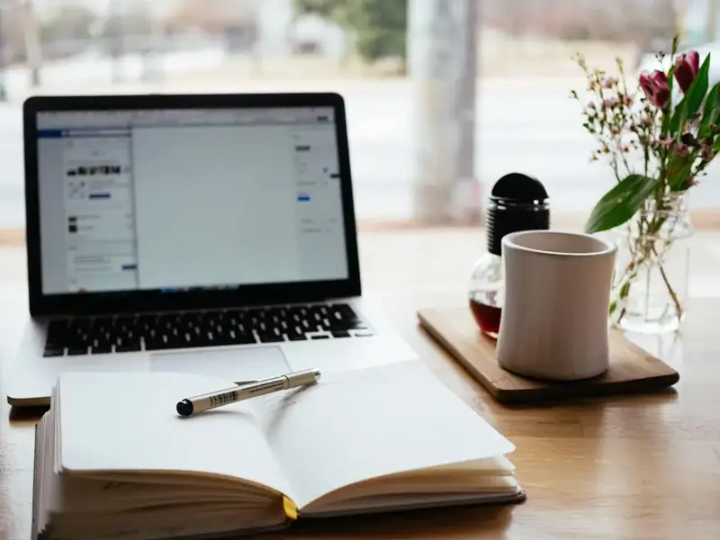 Notebook and pen beside a laptop — the journaling habit