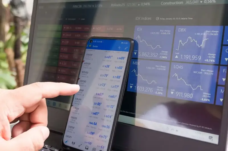 Checking market charts on phone and laptop